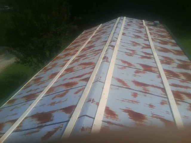 Rusted metal roof panels with new wood purlins before replacement — Storm Damage Roof Repair in Chisago City by Roofing Brothers