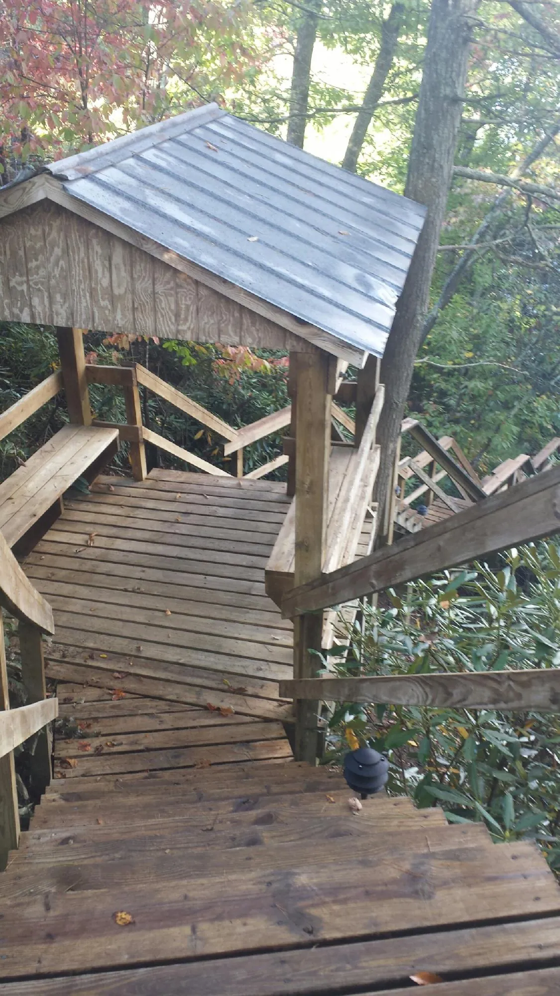 Metal roofed shelter over wooden steps on a wooded walkway — Skylight Repair & Installation work by our crew in Chisago City