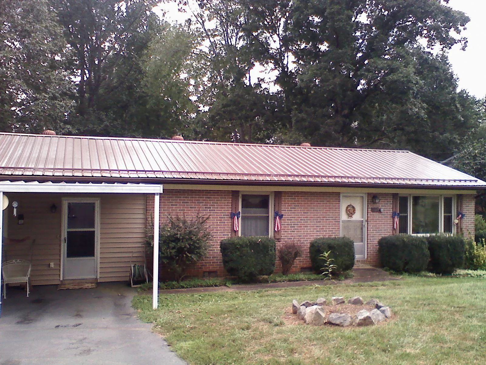 Bronze metal roof and carport on a brick ranch home — Roof Repair work by our crew in Chisago City